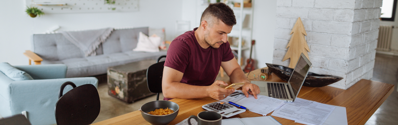 Man working at home desk calculating bills