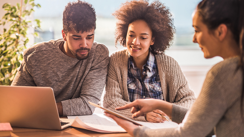 A couple reviewing information about mortgage payments with a financial advisor