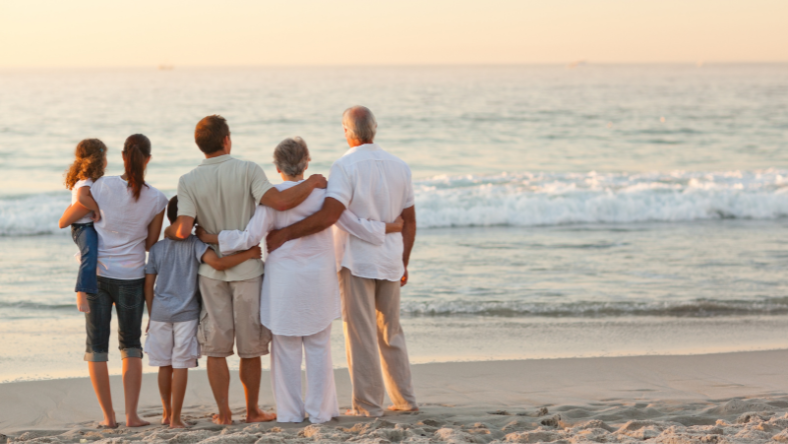 Retired couple on beach with family