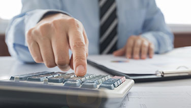 Businessman hand on calculator