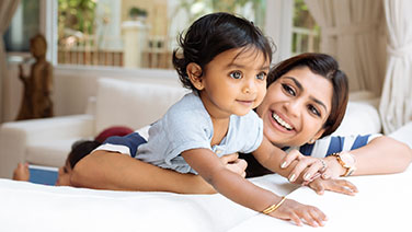 Mother and young daughter sitting on couch