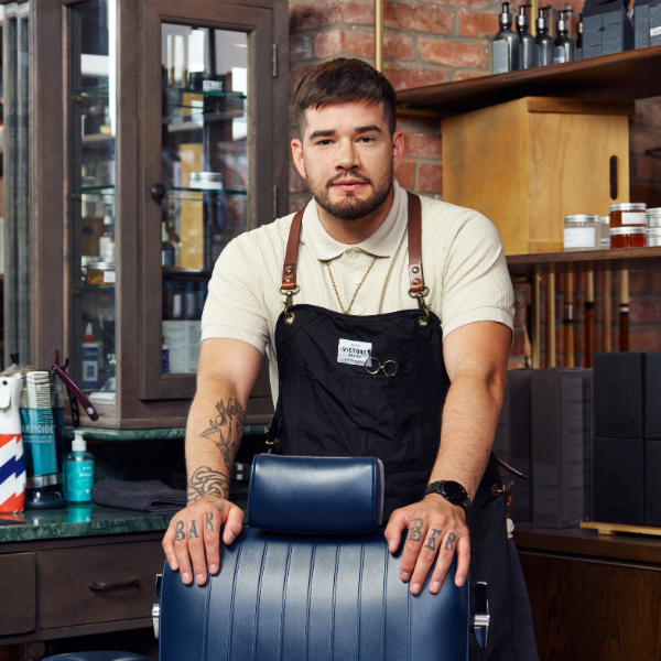 Barber standing behind his client chair