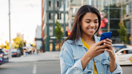 Young woman outside holding mobile phone