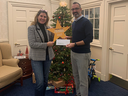 Salem Five employee in front of Christmas tree giving a donation