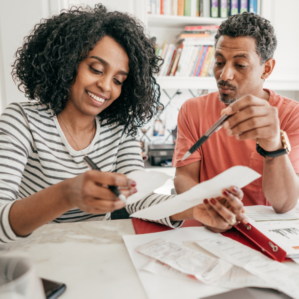 Couple looking through receipts at table.