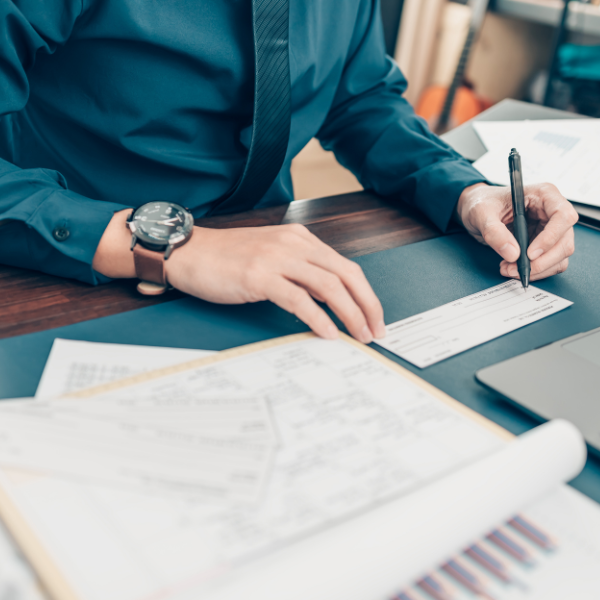 Professional man at desk writing a check.